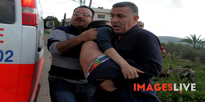 Palestinian protesters carry an injured comrade during clashes with Israeli security forces following a demonstration against the expropriation of Palestinian land by Israel in the village of Kfar Qaddum, near Nablus, in the occupied West Bank, on March 4, 2016. / Photographer: Mohammed Turabi  Images Live