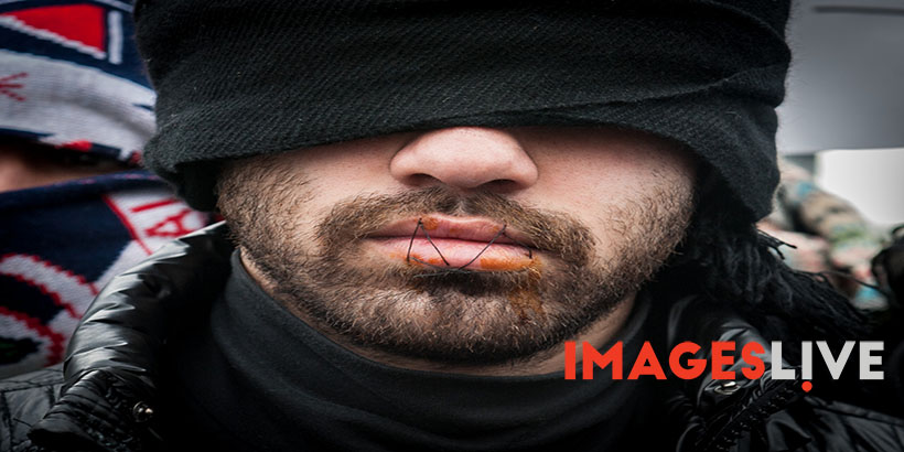 Jungle, Calais, France. 02 March, 2016. A group of Iranian refugees sew up their mouths to signify that their voices are not being heard by the French authorities demolishing the Calais Jungle camp in Northern France.