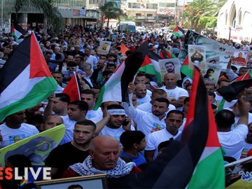 Palestinians hold pictures of Palestinians detained in Israeli prisons during a demonstration to mark Palestinian Prisoner Day in the West Bank city of Nablus on April 17, 2016. (Mohammed Turabi).