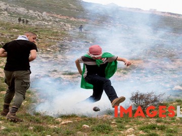 Palestinian demonstrators react amidst tear gas smoke fire by Israel forces during a protest to mark land day in village of Madama, south of Nablus, on March 30, 2017 in the Israeli occupied West Bank. Land Day marks the killing of six Arab Israelis during 1976 demonstrations against Israeli confiscations of Arab land.