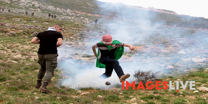 Palestinian demonstrators react amidst tear gas smoke fire by Israel forces during a protest to mark land day in village of Madama, south of Nablus, on March 30, 2017 in the Israeli occupied West Bank. Land Day marks the killing of six Arab Israelis during 1976 demonstrations against Israeli confiscations of Arab land.